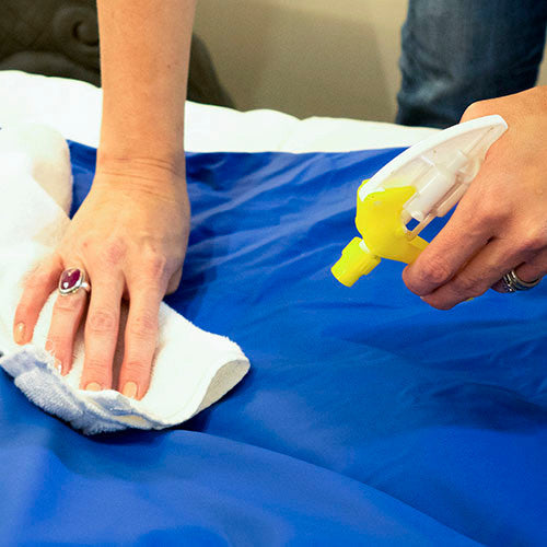 Wipe-Clean Weighted Blanket demonstrating cleaning with standard sanitizer spray